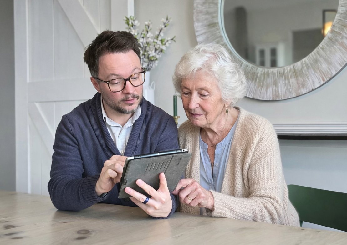 Jordan Wiberg from Helping Hand Tech helping a senior woman with her tablet in Lake Country BC